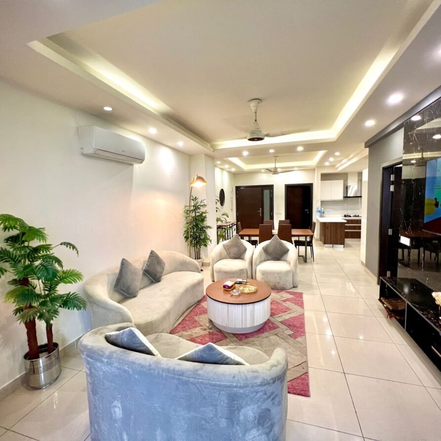Elegant living room with designer golden sofas in executive 2-bedroom apartment facing Centaurus, Islamabad